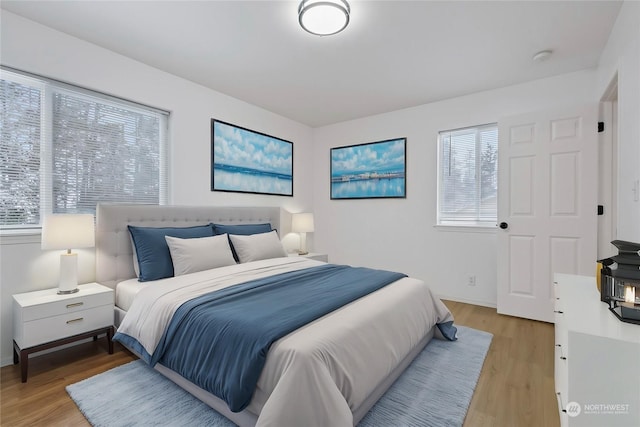 bedroom with multiple windows and light wood-type flooring