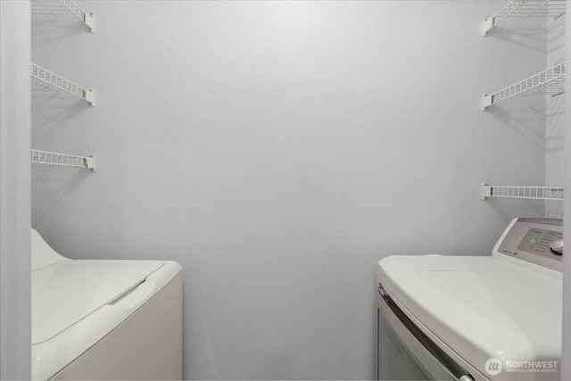 clothes washing area featuring laundry area and washing machine and clothes dryer