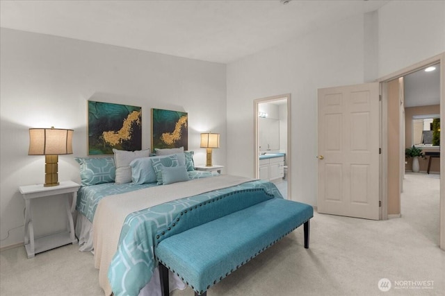 bedroom featuring baseboards, light carpet, and ensuite bath