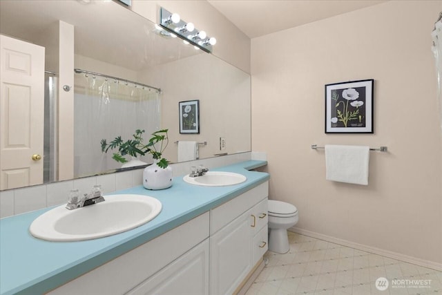 full bathroom with double vanity, a sink, toilet, and tile patterned floors