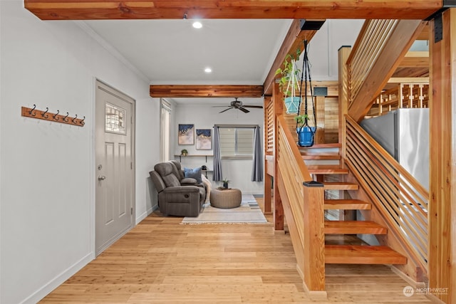 staircase with crown molding, hardwood / wood-style floors, and ceiling fan