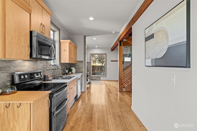 kitchen featuring sink, appliances with stainless steel finishes, light hardwood / wood-style floors, light brown cabinetry, and decorative backsplash