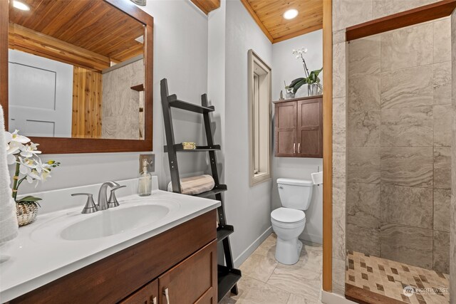 bathroom featuring a tile shower, vanity, wooden ceiling, and toilet