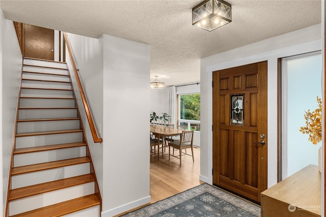 foyer featuring a textured ceiling and light wood-type flooring