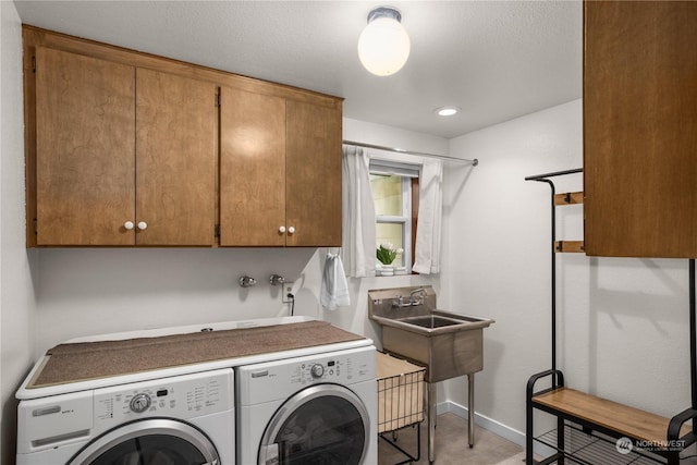 laundry area featuring cabinets, sink, and washing machine and dryer