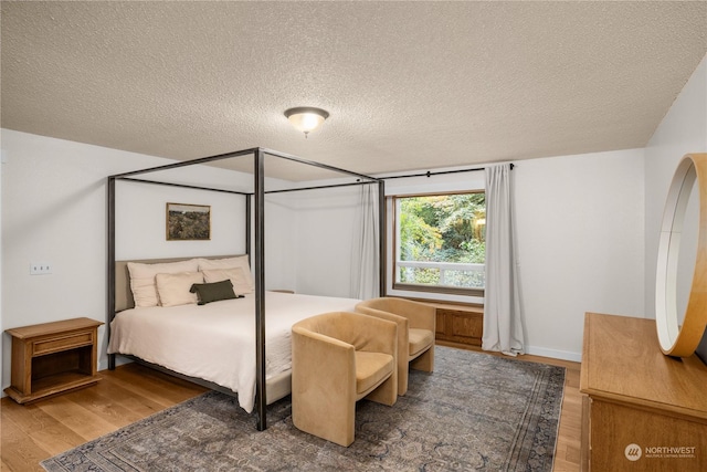 bedroom with hardwood / wood-style floors and a textured ceiling