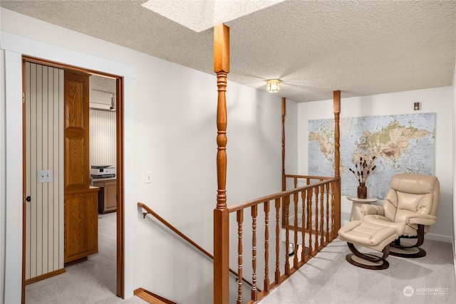 hall with light carpet and a textured ceiling