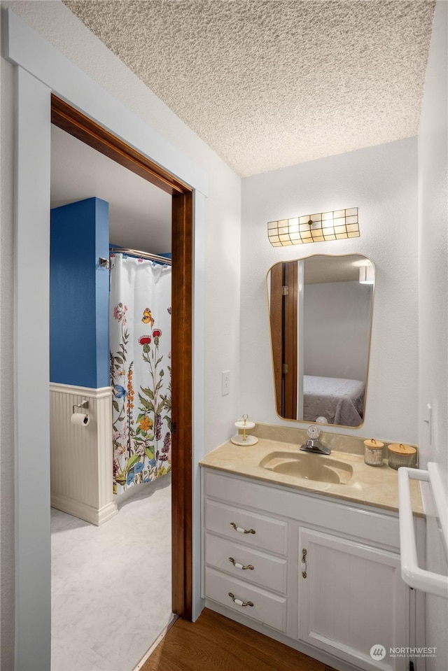 bathroom featuring vanity, hardwood / wood-style floors, and a textured ceiling