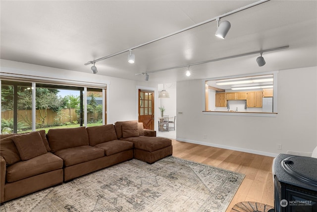 living room featuring rail lighting and light hardwood / wood-style floors