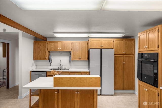 kitchen featuring a kitchen island, appliances with stainless steel finishes, sink, and beam ceiling