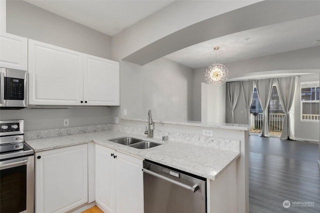 kitchen with sink, white cabinetry, kitchen peninsula, stainless steel appliances, and light stone countertops