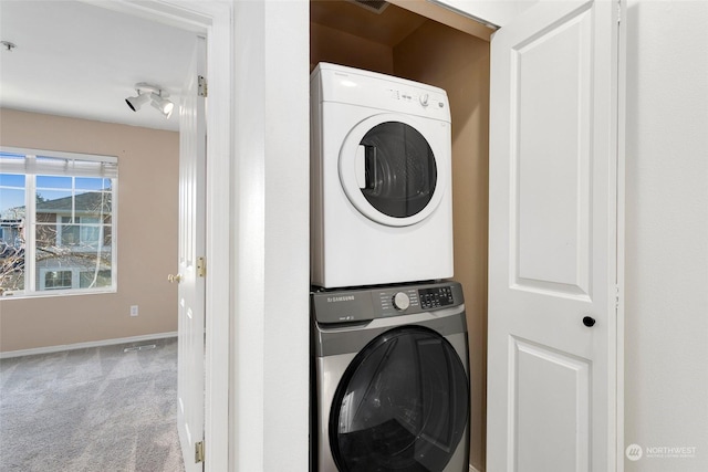 laundry area with stacked washer and clothes dryer and carpet flooring