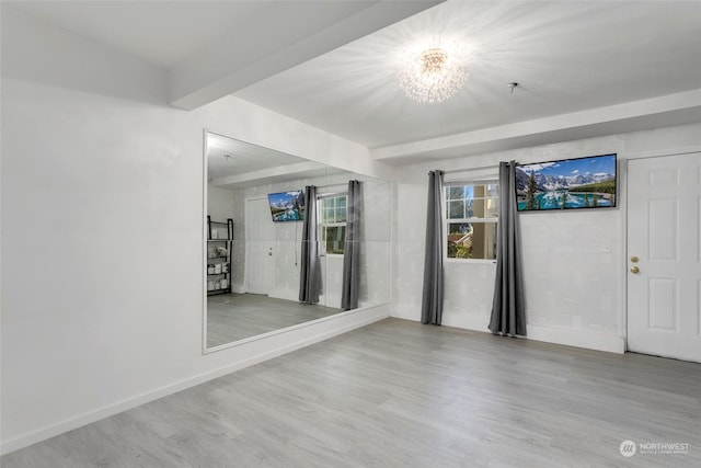 spare room with hardwood / wood-style flooring and beamed ceiling