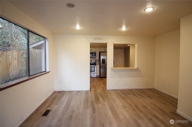 unfurnished room with light wood-type flooring