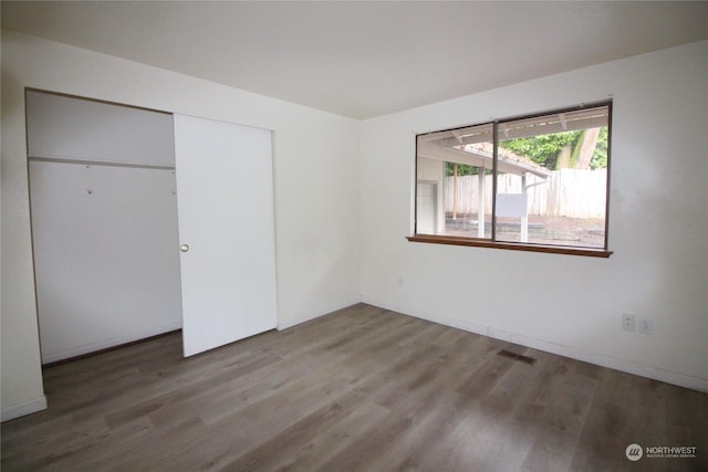 unfurnished bedroom with hardwood / wood-style floors and a closet