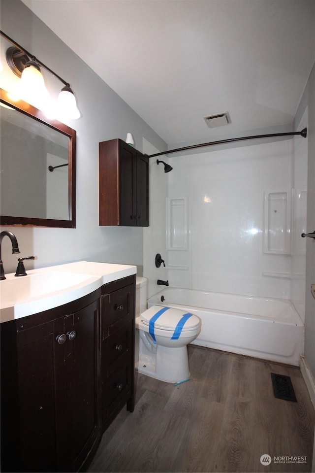 full bathroom with vanity, bathtub / shower combination, hardwood / wood-style floors, and toilet