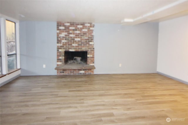 unfurnished living room with light wood-type flooring and a fireplace