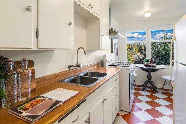 kitchen with white cabinetry, white appliances, wall chimney exhaust hood, and sink