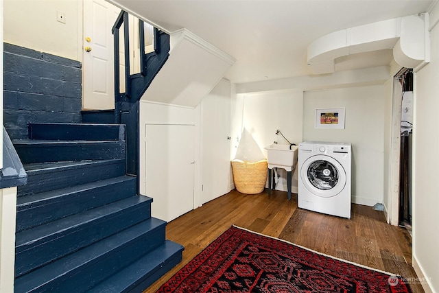 clothes washing area featuring dark wood-type flooring, washer / clothes dryer, and sink