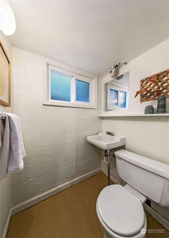 bathroom with concrete flooring and toilet