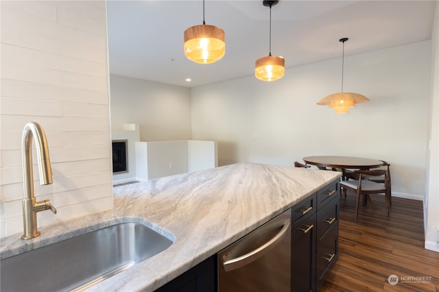 kitchen featuring dark hardwood / wood-style floors, decorative light fixtures, dishwasher, sink, and light stone countertops