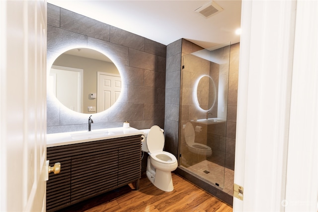 bathroom featuring hardwood / wood-style flooring, vanity, tile walls, and toilet