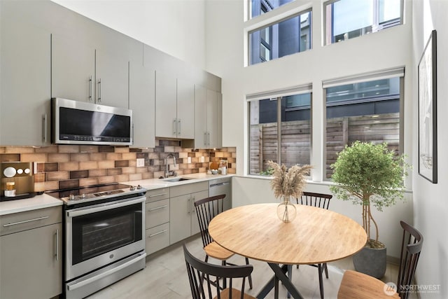 4407 42nd Ave SW Unit D, Seattle, WA 98116 - kitchen featuring a sink, a wealth of natural light, gray cabinetry, and stainless steel appliances