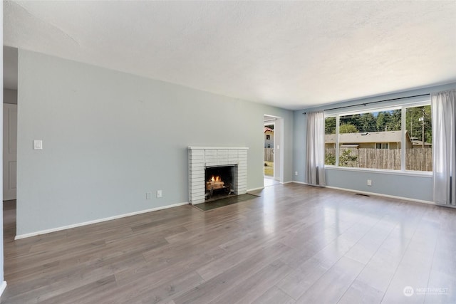 unfurnished living room with wood-type flooring and a fireplace