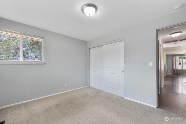 unfurnished bedroom with light carpet and a closet