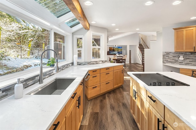 kitchen featuring dark wood-type flooring, vaulted ceiling with beams, a sink, black electric stovetop, and backsplash