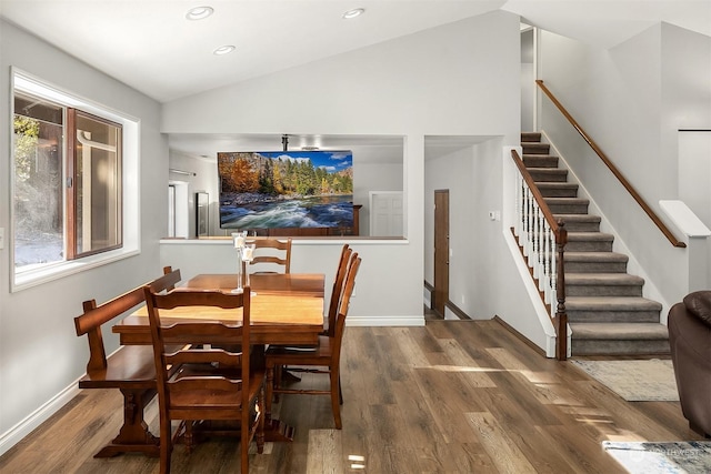 dining area featuring lofted ceiling, recessed lighting, wood finished floors, baseboards, and stairs