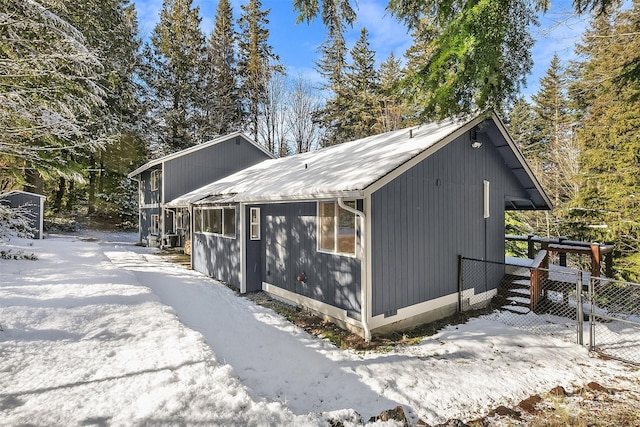 snow covered property with a gate and fence