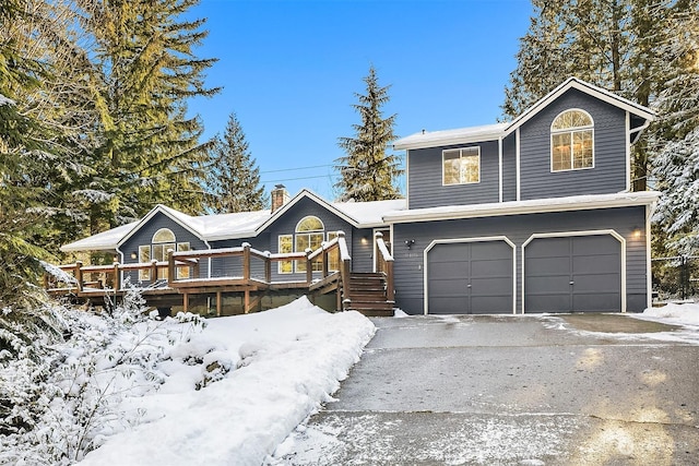 view of front facade featuring driveway, a wooden deck, and an attached garage