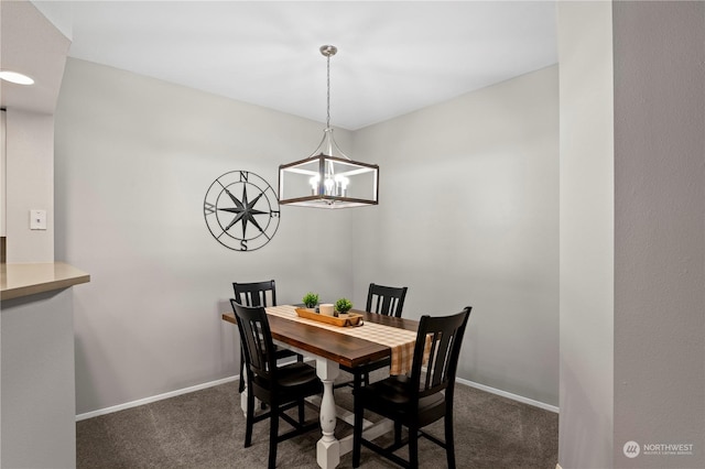 dining area featuring an inviting chandelier and dark carpet