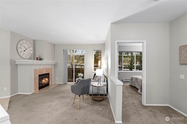 sitting room with a tiled fireplace and light colored carpet