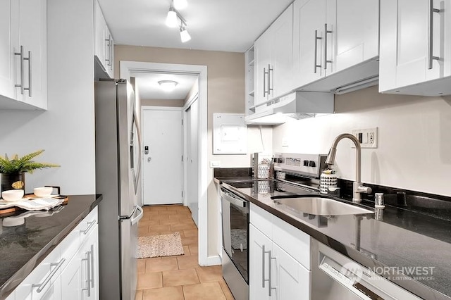 kitchen with appliances with stainless steel finishes, sink, white cabinets, and dark stone counters