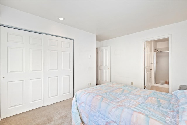 carpeted bedroom featuring connected bathroom and a closet