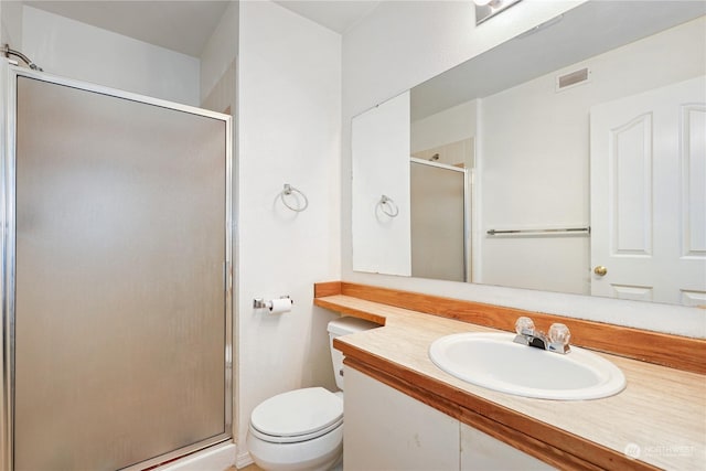 bathroom featuring vanity, an enclosed shower, and toilet