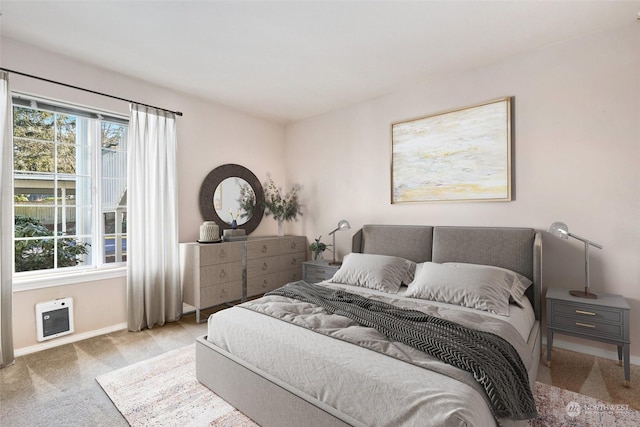 carpeted bedroom featuring multiple windows and heating unit