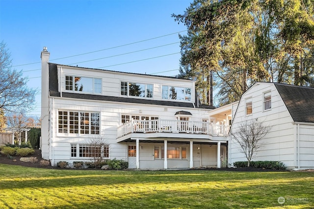 rear view of property with a wooden deck and a lawn