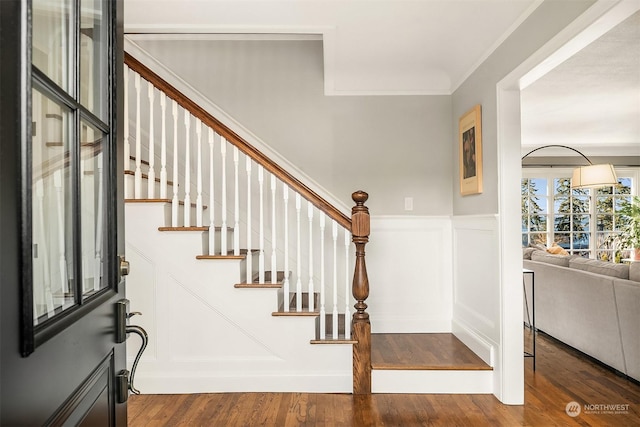 entrance foyer featuring crown molding and dark wood-type flooring