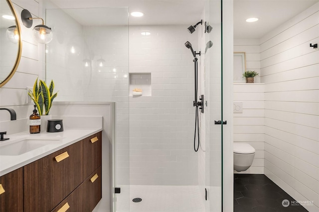 bathroom featuring a shower with door, vanity, and toilet