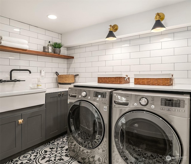 laundry area with cabinets, independent washer and dryer, sink, and light tile patterned floors