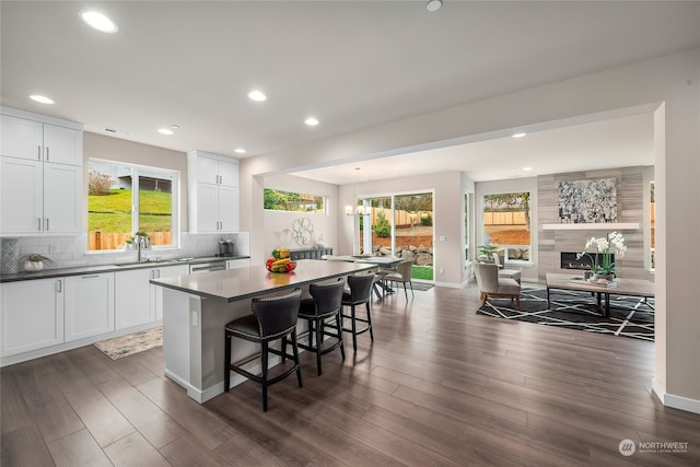 kitchen featuring tasteful backsplash, a center island, white cabinets, and a kitchen bar