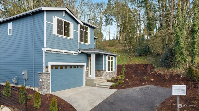 view of front of property featuring board and batten siding, a garage, stone siding, and driveway