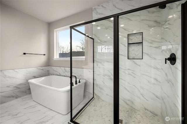 bathroom featuring tile walls, a freestanding tub, marble finish floor, and a marble finish shower