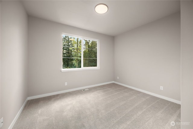 empty room featuring visible vents, baseboards, and carpet flooring