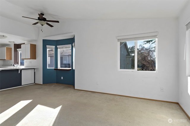 unfurnished living room featuring vaulted ceiling, light carpet, and ceiling fan