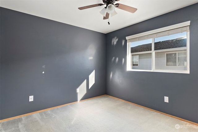 spare room featuring ceiling fan and carpet