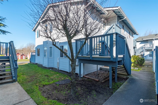 view of front of property featuring a front lawn and a deck